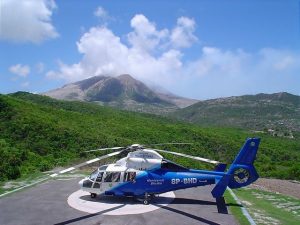 The contracted MVO Helecopter, named "Montserrat Shuttle", on the helipad at the MVO with the Soufriere Hills Volcano in the background